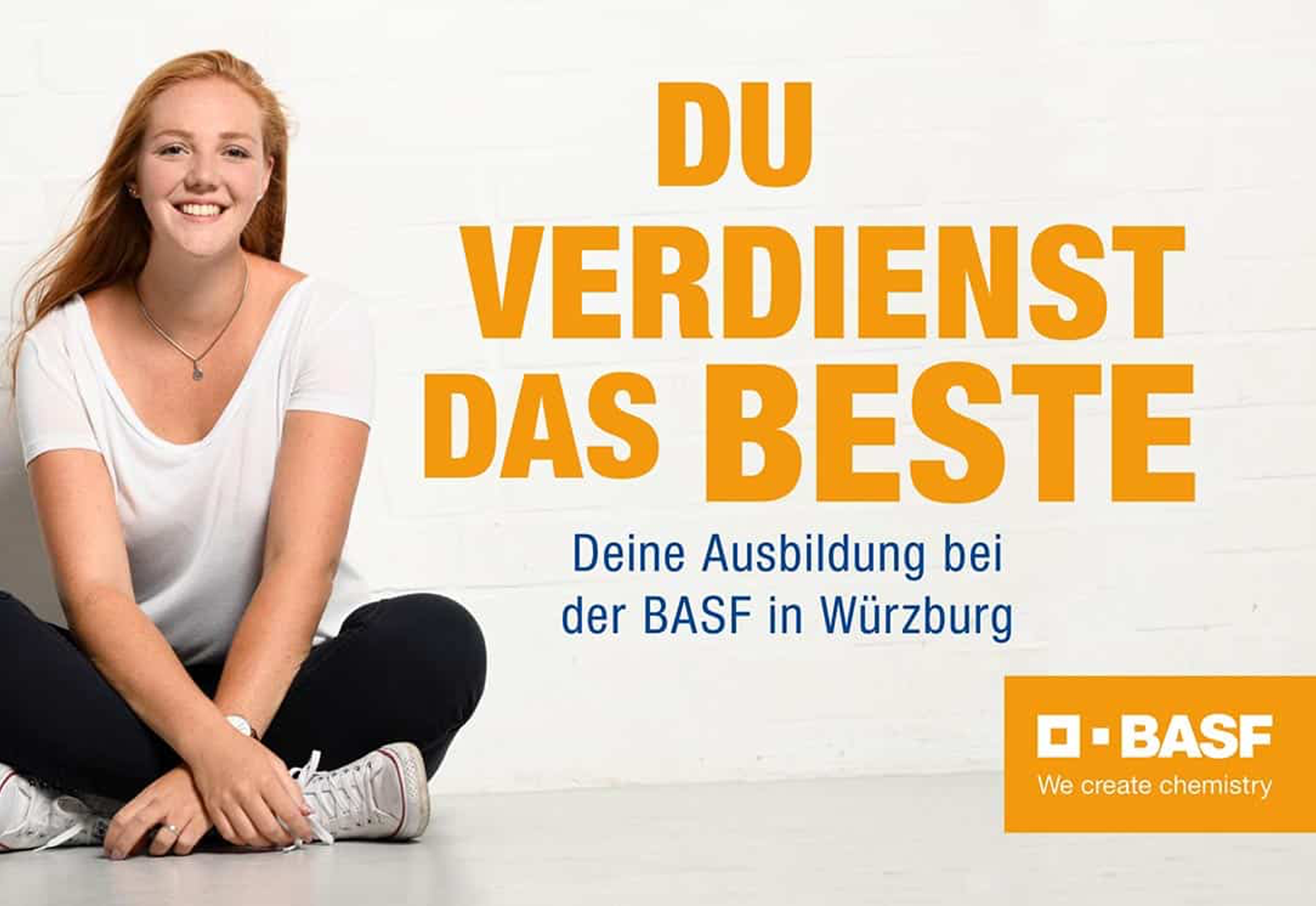 Junge Auszubildende sitzt entspannt vor einer weißen Wand und vermittelt Nähe und Authentizität innerhalb der BASF-Ausbildungskampagne.