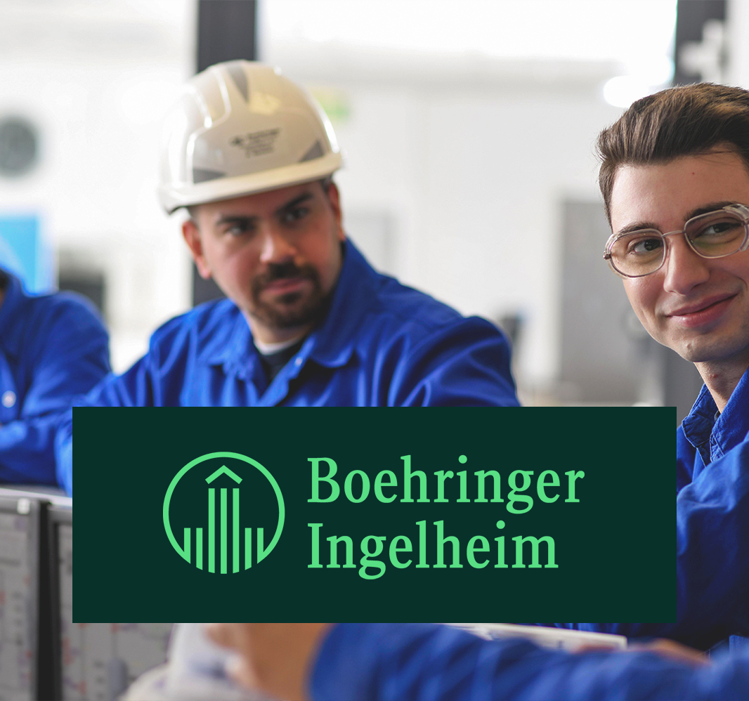 Mitarbeiter in blauer Arbeitskleidung beim Austausch im Produktionsumfeld von Boehringer Ingelheim