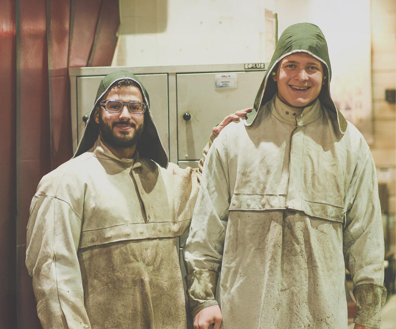 Zwei Auszubildende in Schutzkleidung in einer Produktionshalle bei Schmitz Cargobull