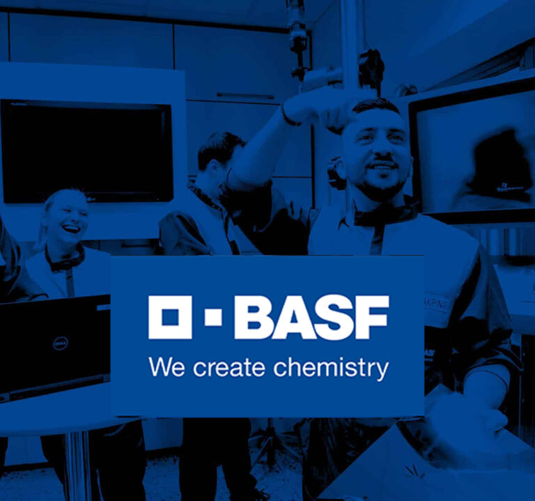 Mitarbeitende der BASF in Laborumgebung mit BASF-Logo im Vordergrund