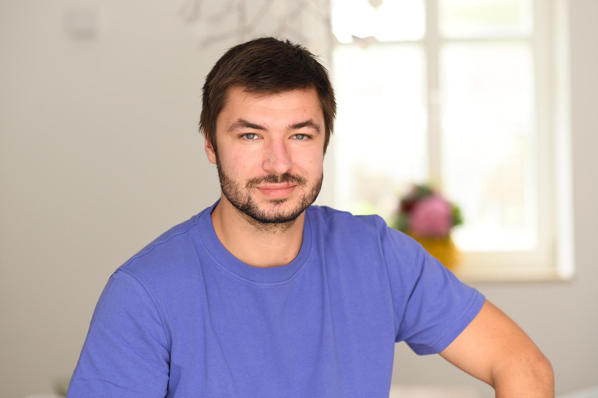 Mitarbeiter der Agentur Heldenstreich sitzt entspannt im Büro und blickt freundlich in die Kamera.