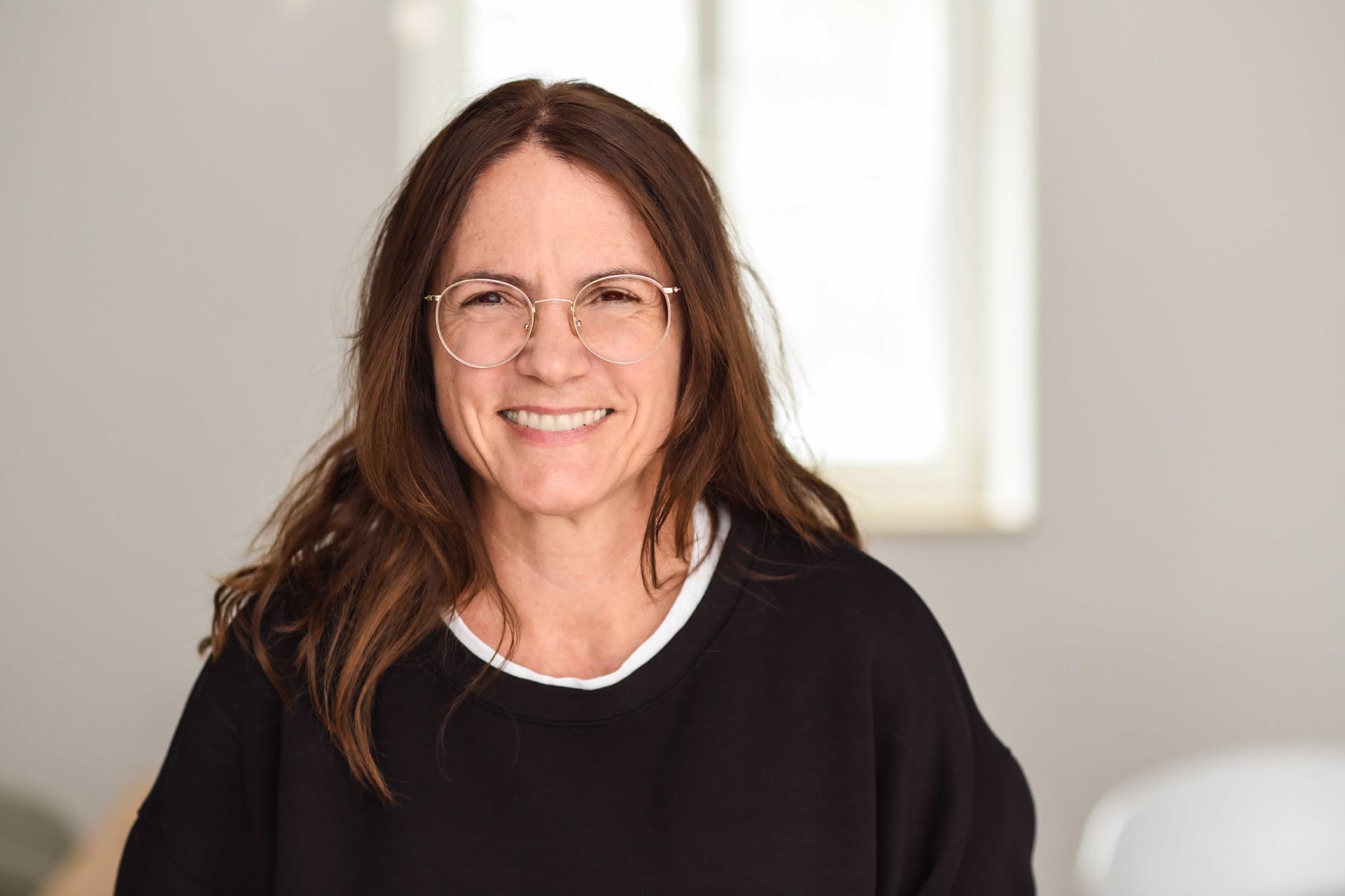 Teammitglied der Agentur Heldenstreich lächelt in freundlicher Büroatmosphäre