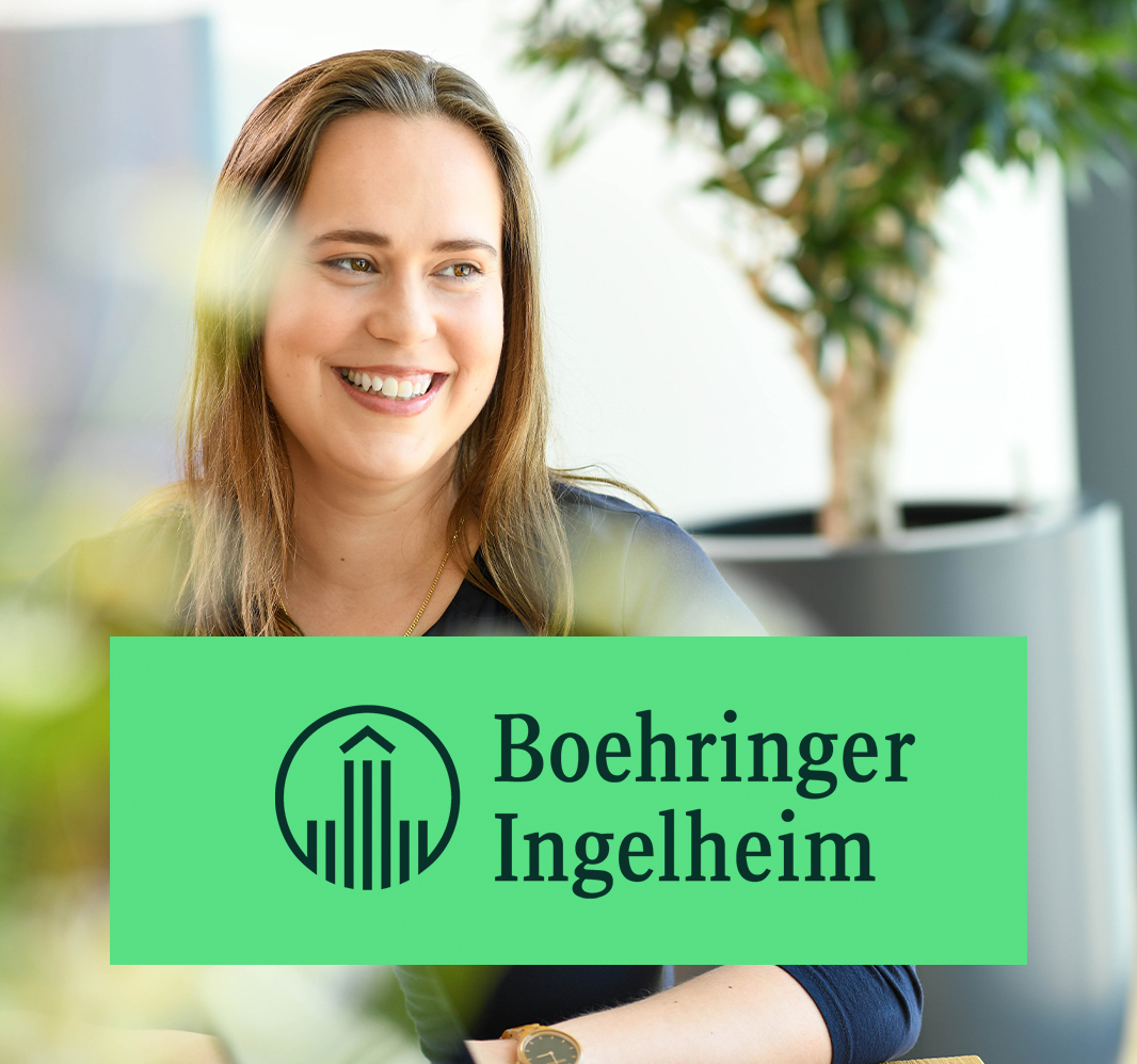 Mitarbeiterin bei Boehringer Ingelheim lächelt in heller, moderner Büroumgebung.
