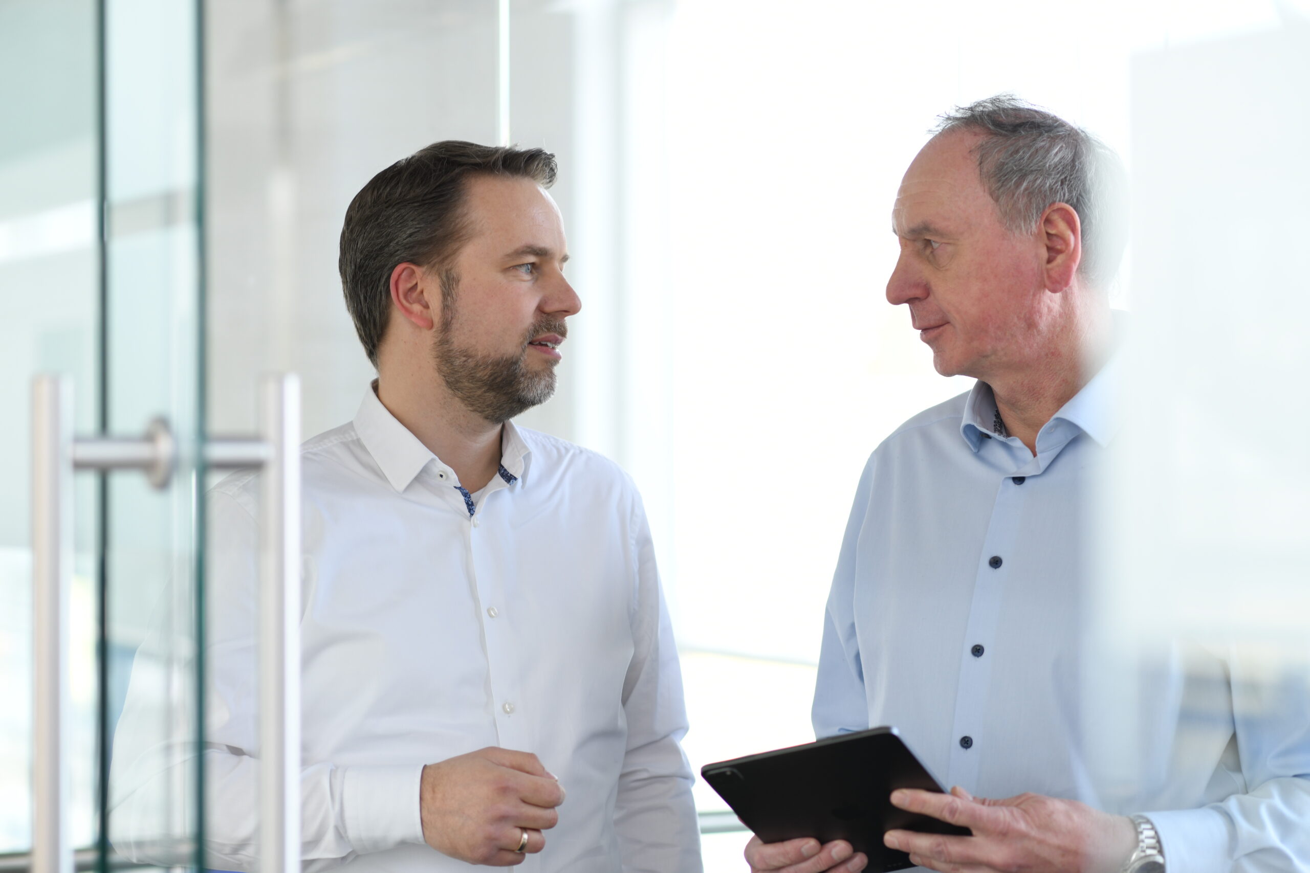 Zwei Mitarbeiter von Widmann & Winterholler im Gespräch im Autohaus