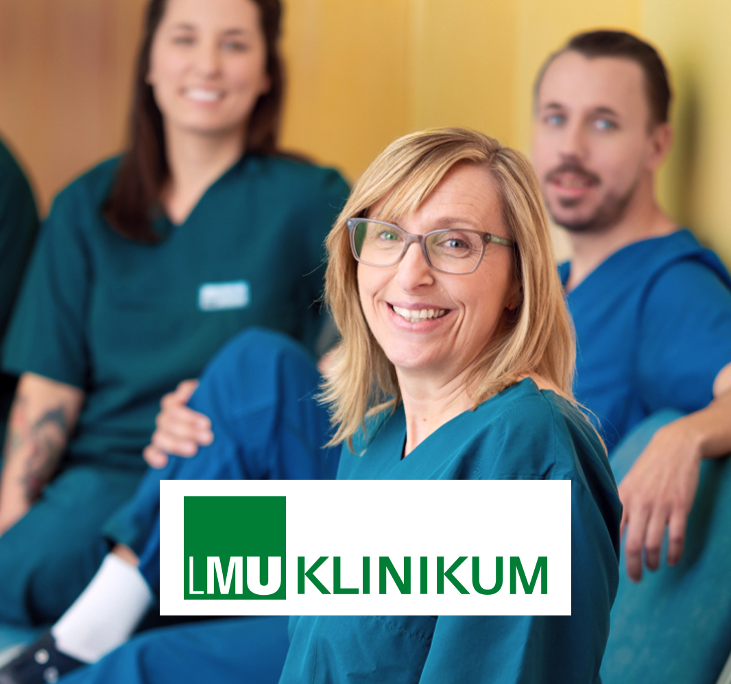 Pflegekräfte des LMU Klinikums sitzen gemeinsam und lächeln in die Kamera.