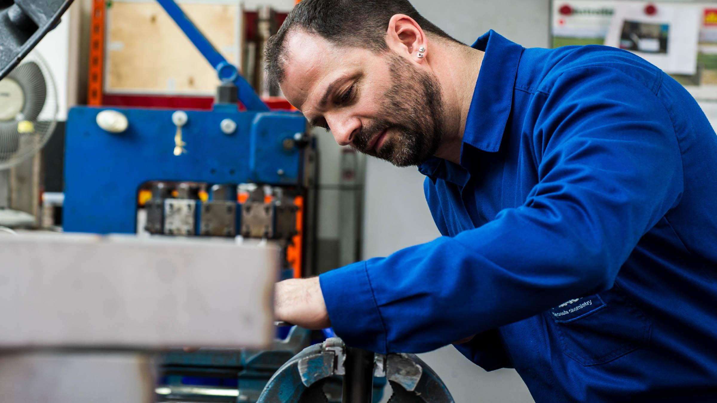 Mitarbeiter bei BASF Coatings Würzburg arbeitet konzentriert an einer Maschine in der Produktion.