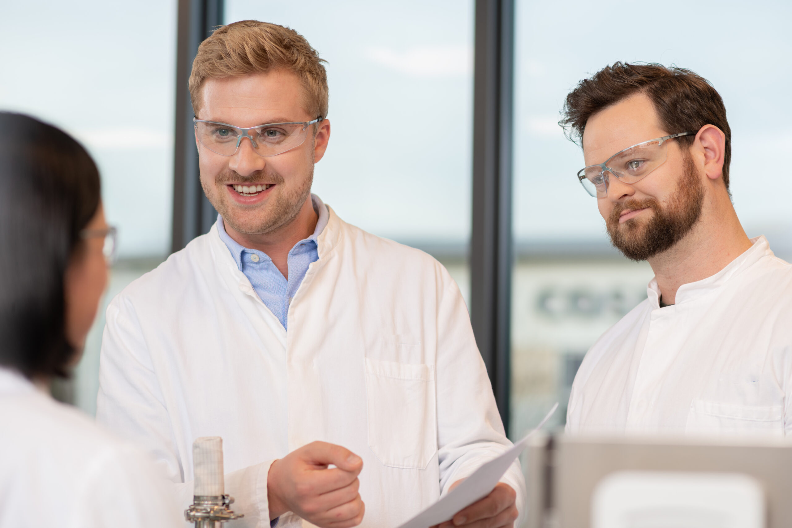 Auszubildende und Mitarbeitende bei AMW im Labor im fachlichen Austausch während der praktischen Ausbildung
