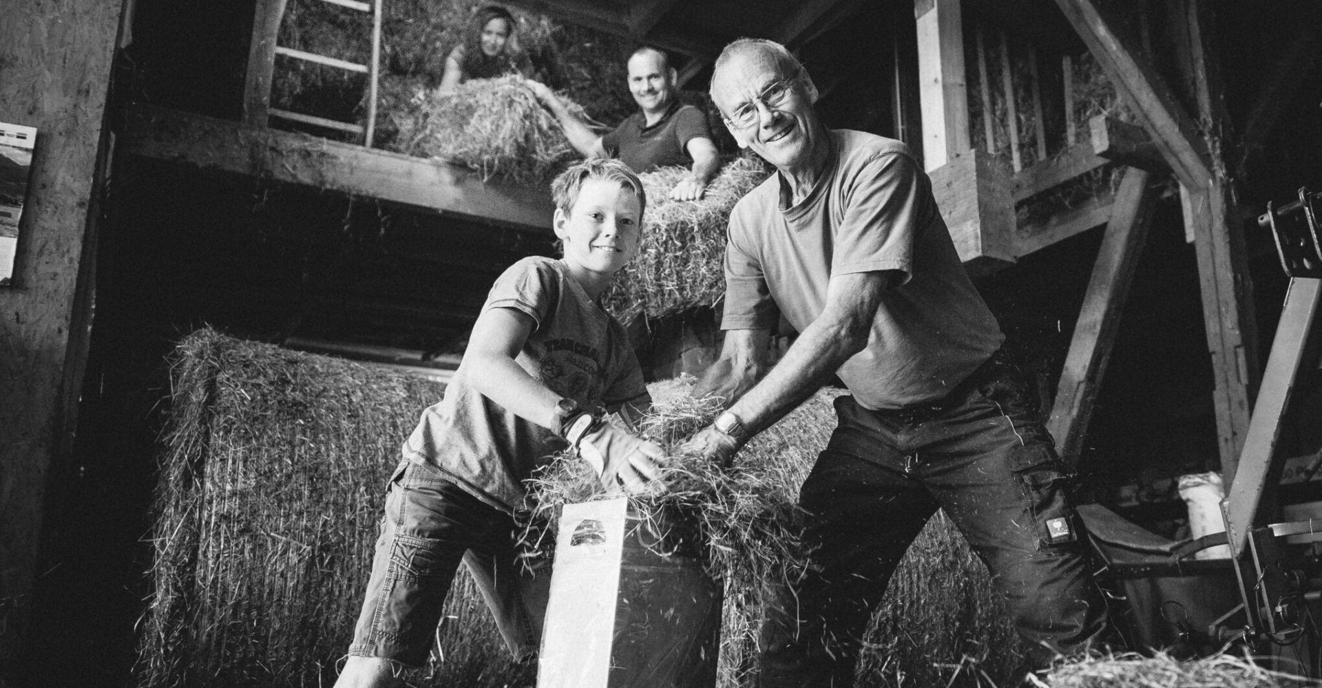 Mehrgenerationen-Familie auf einem Bauernhof der Rhön beim Arbeiten mit Heu – authentische regionale Landwirtschaft für Rhönwiese