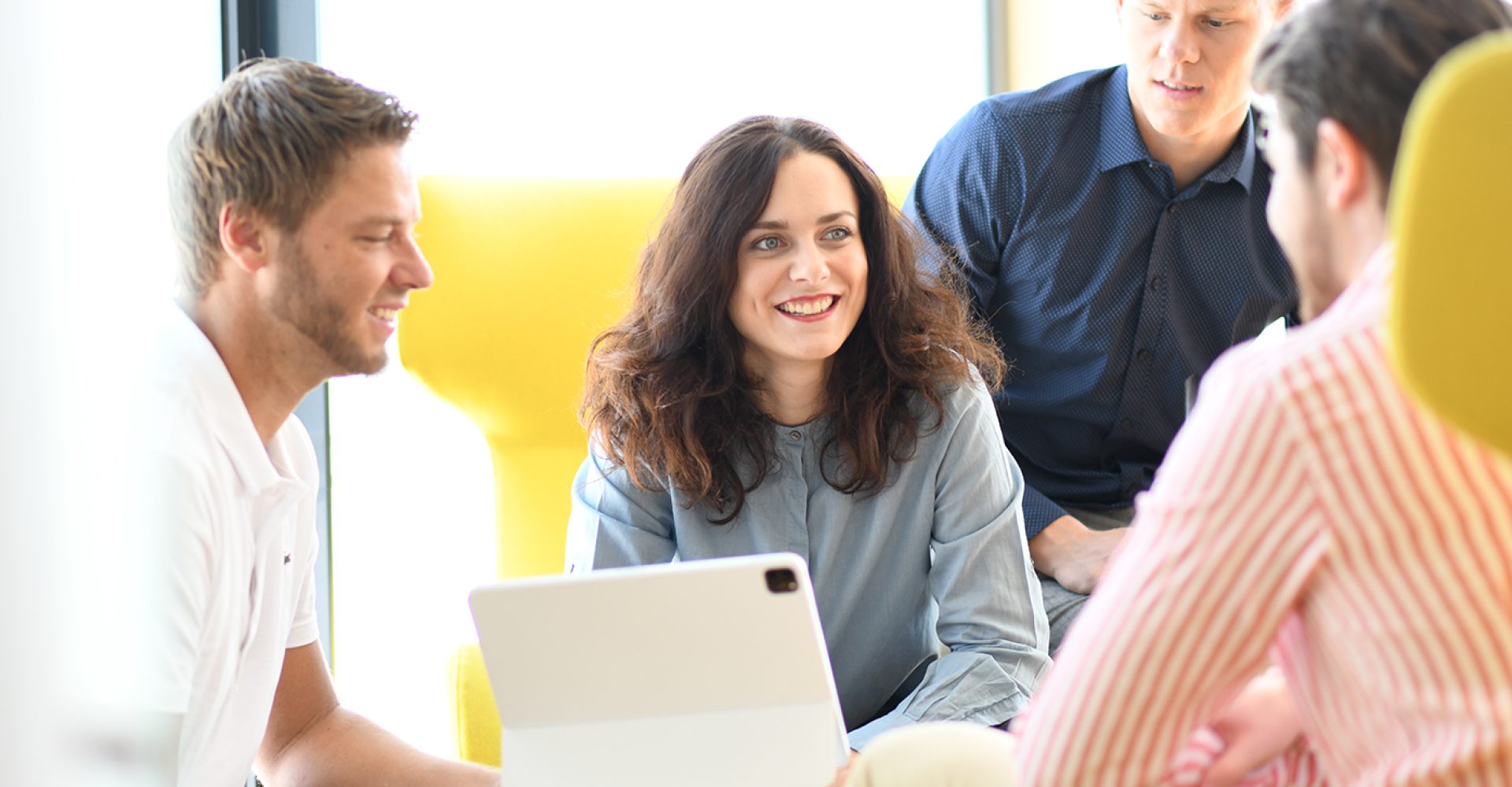 Teammeeting bei PKS in modernen Büroräumen mit vier Mitarbeitenden im Gespräch