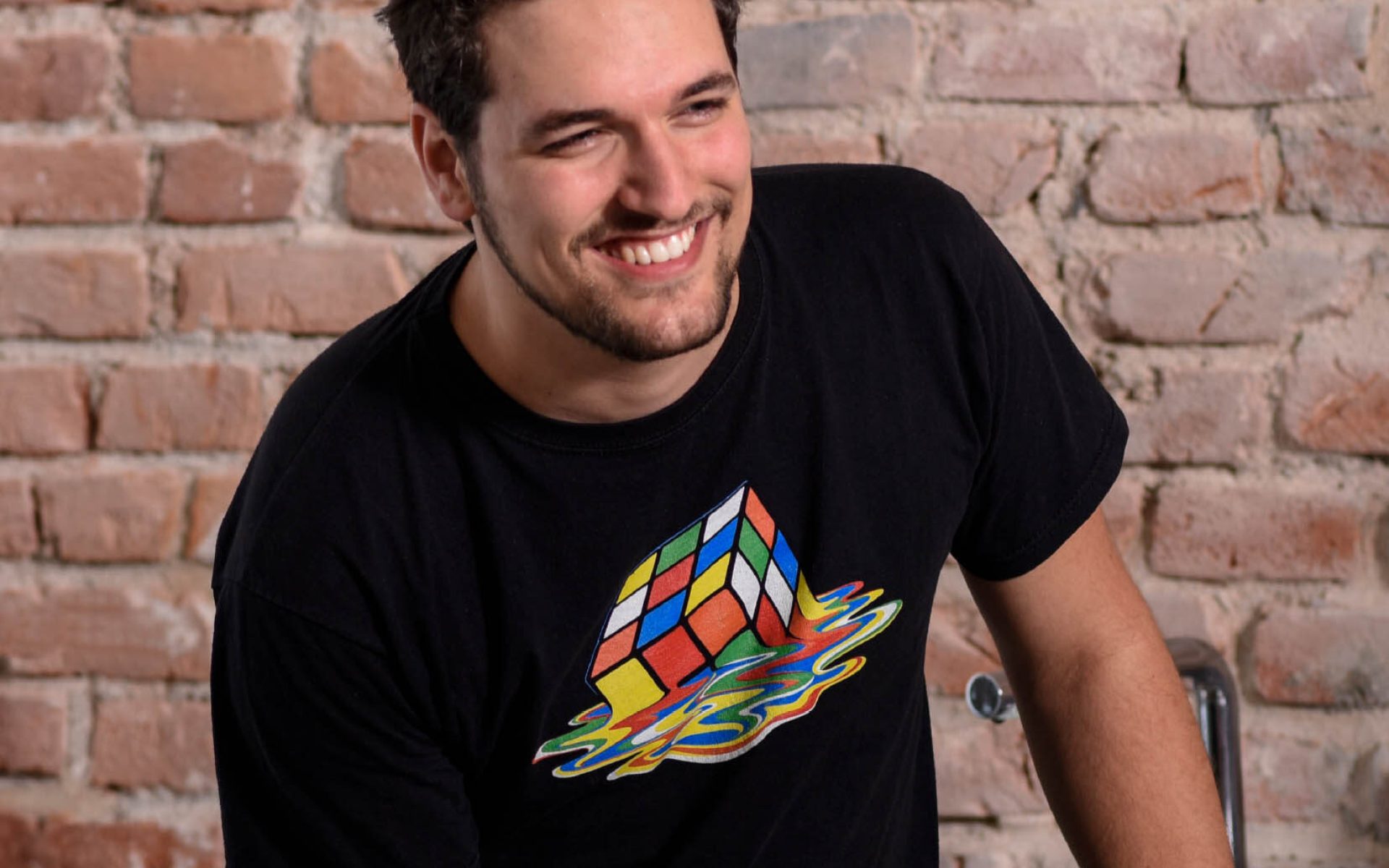 Lachender CPL-Mitarbeiter vor Backsteinwand – authentisches Employer-Branding Porträt